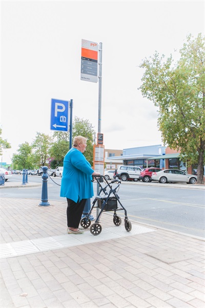 Woman with walker at bus stop